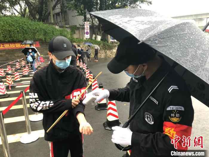 图为工作人员为市民测体温。 钟旖 摄 测体温、控人数 重庆公墓(陵园)实行分时预约祭扫